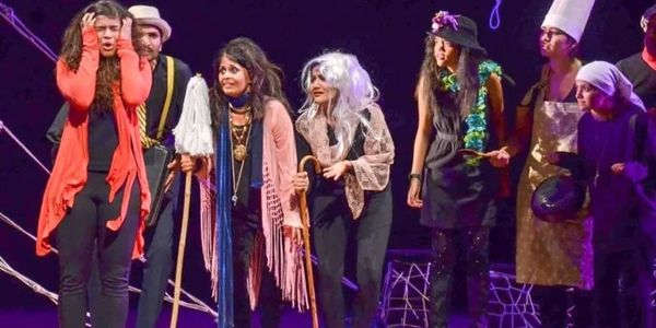 Actors in Halloween costumes perform on stage.