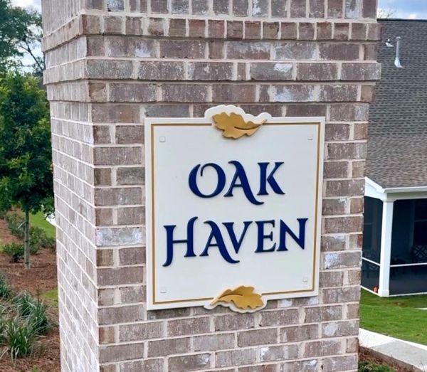 Brick pillar sign reading 'Oak Haven' with oak leaf decorations.