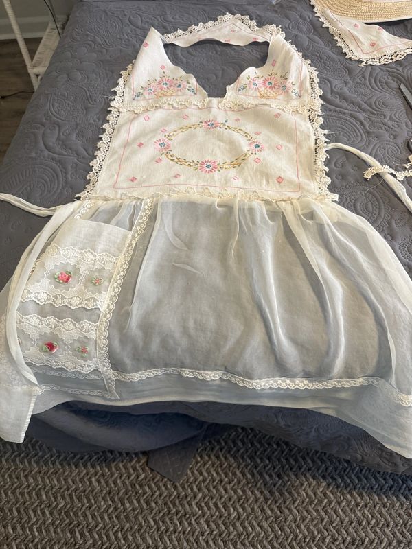 Vintage embroidered apron with lace and floral details.