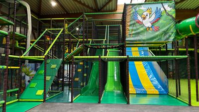 Indoor kids' play area with slides and climbing structures.