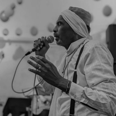 Black and white photo of a man passionately singing into a microphone.