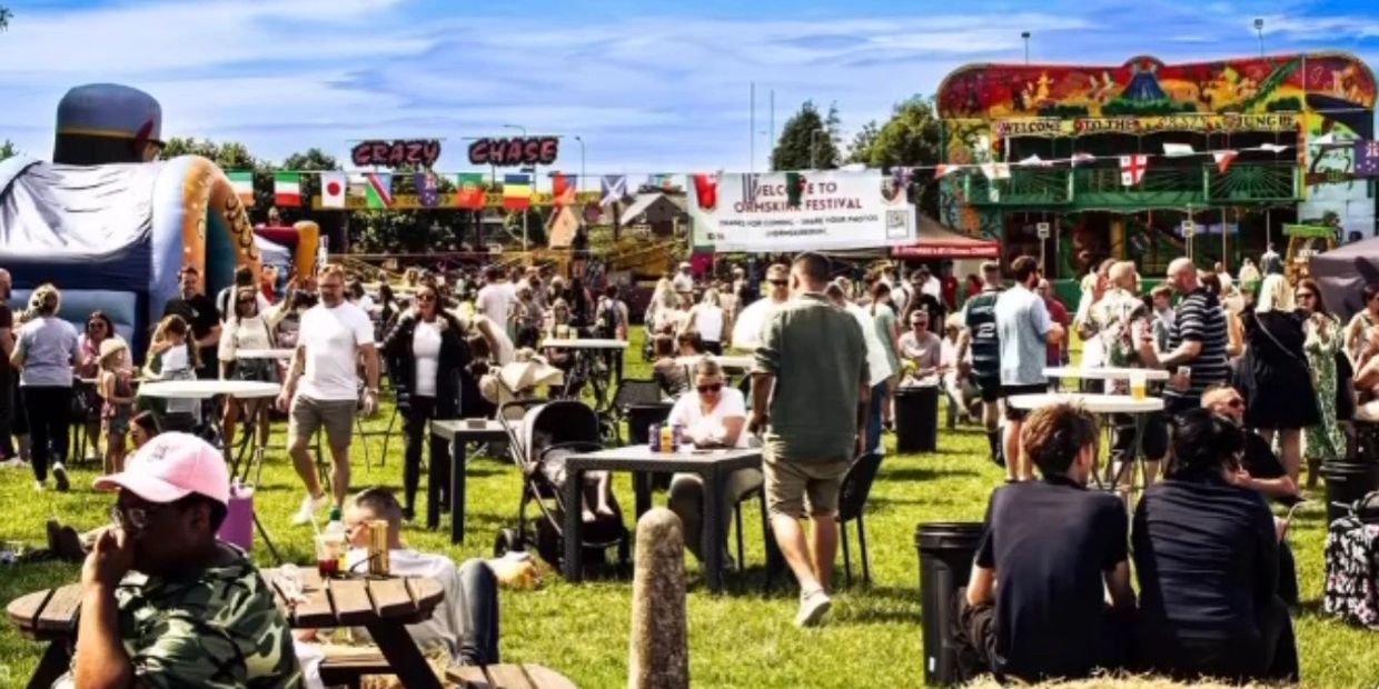Crowded outdoor festival with people enjoying food, games, and socializing on a sunny day.