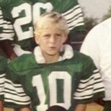Youth football team photo from 1983 with players and coaches in green uniforms.