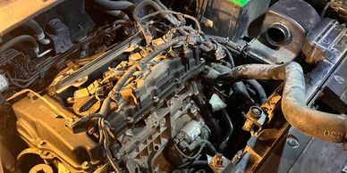 Close-up of a car engine with visible hoses and wiring.