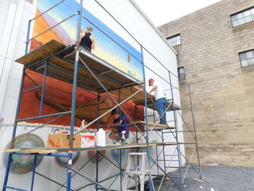 Lori, Nikki, and Mark painting the outdoor Mount Carmel VFW mural, America the Beautiful