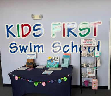 Welcome table and rack at Kids First Swim School.