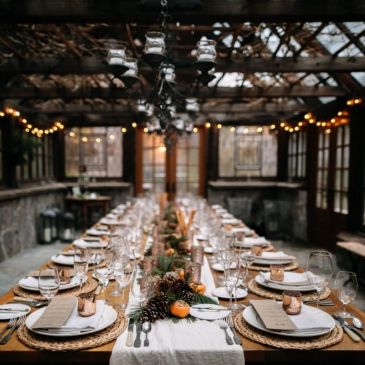 Elegant rustic dining table set for a festive gathering under warm lights.