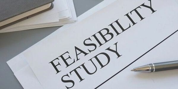 A printed document titled 'Feasibility Study' with a pen beside it.