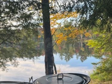 Pot on a camp stove overlooking pond