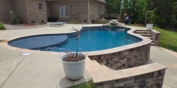 Pool with deck step down and stone waterfall