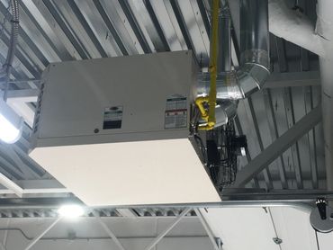 Commercial reznor heater hanging from ceiling in large commercial garage