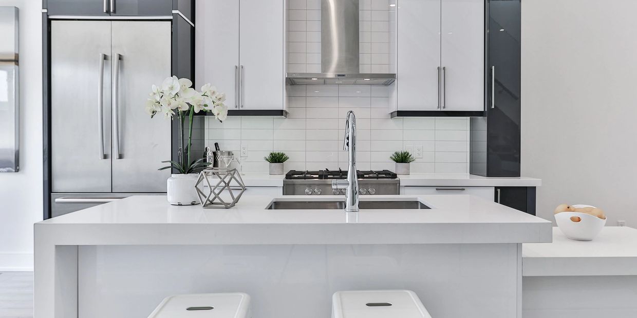 White Kitchen with black accents and stainless steel appliances.