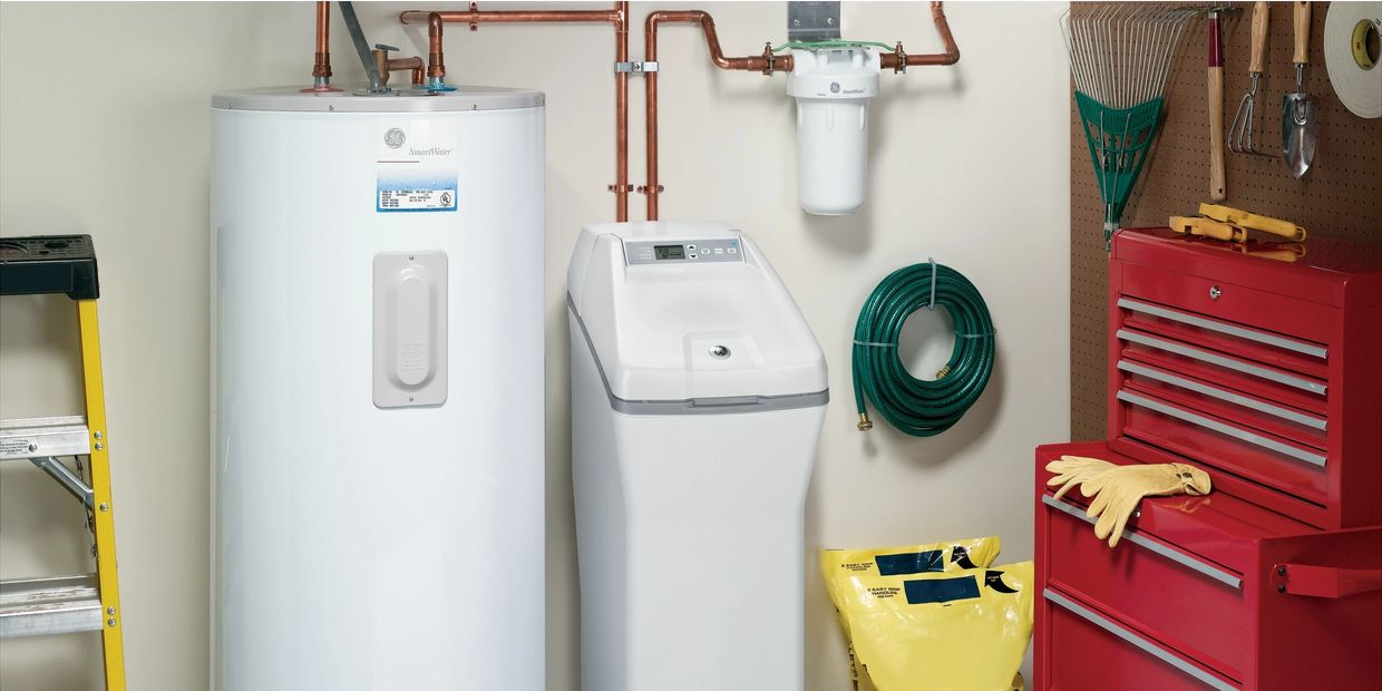 Water Softener positioned by hot water heater and red tool box.