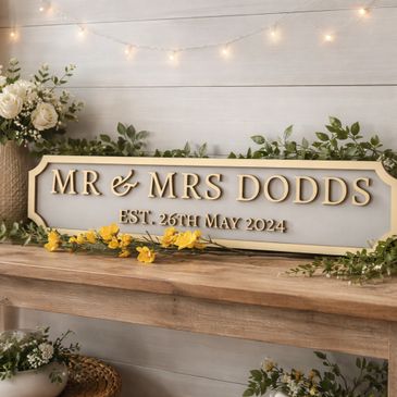 Wedding sign for Mr. and Mrs. Dodds with floral decorations and candles.