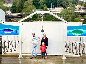 Coho salmon with a family onboard Reel Alaska Fishing Charters in Ketchikan