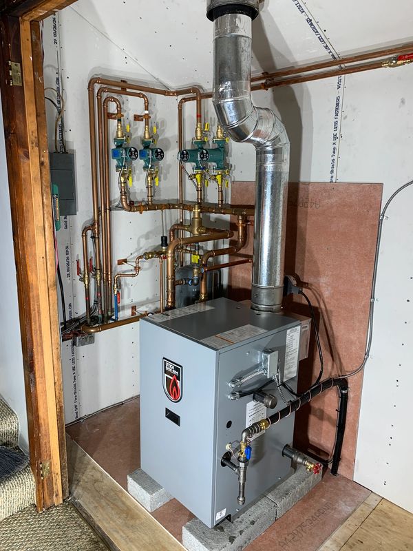 Newly installed heating system with copper piping and ventilation duct.