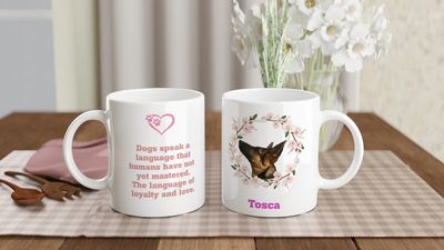 White mugs with a dog picture and quote on a table.