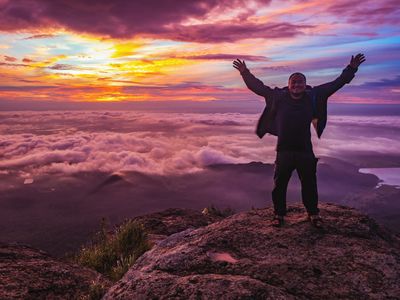 Man with upraised arms on top of mountain. Image credit: Sumeth - stock.adobe.com