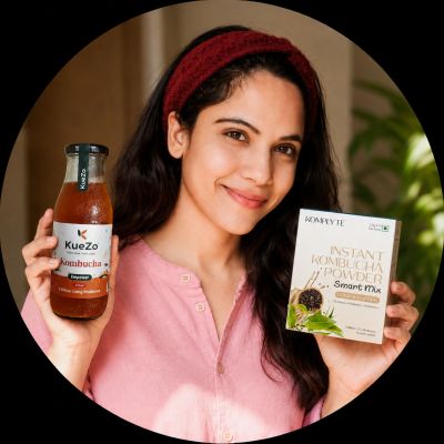 Woman holding kombucha drink and instant kombucha powder box.