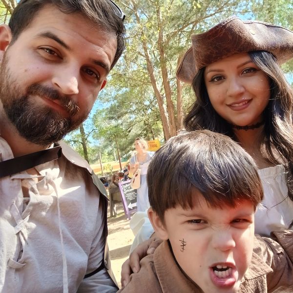 A family dressed in medieval costumes enjoying a sunny day outdoors.