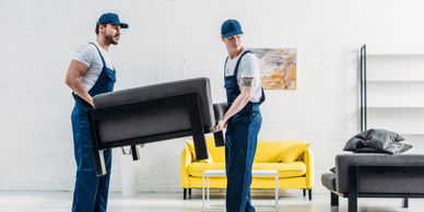 Two movers carrying a chair in a bright living room.