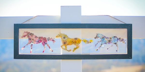 Three colorful horse silhouettes made of flowers.