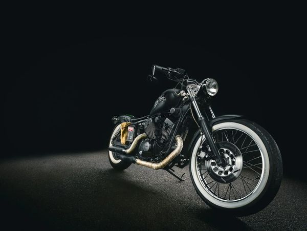 A black custom motorcycle with whitewall tires.