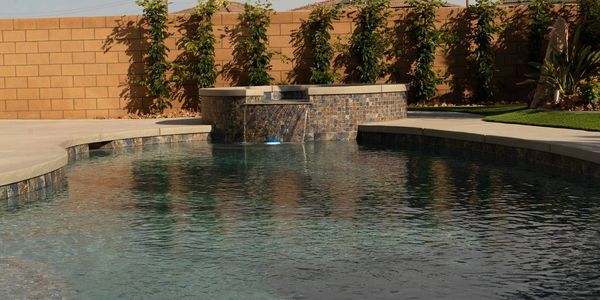 A pool with its own waterfall in the middle of the dessert, pool constructed by Poolco Pools 