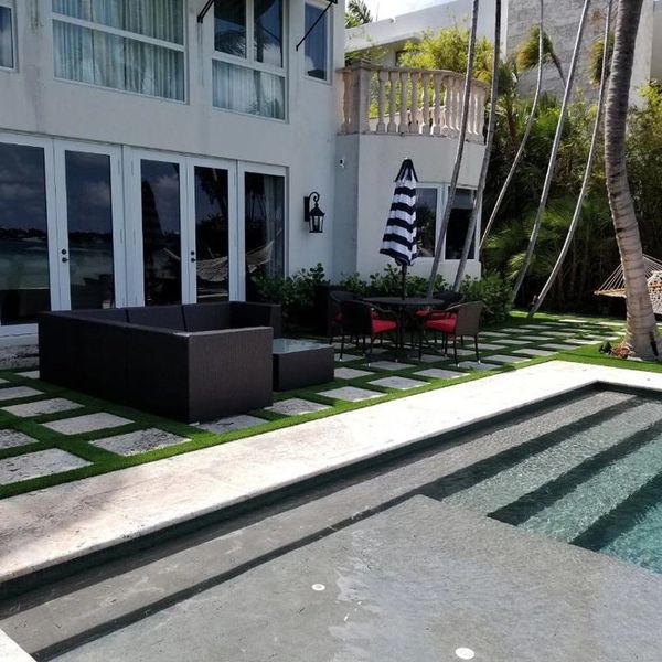 Synthetic grass strips between concrete pavers Miami