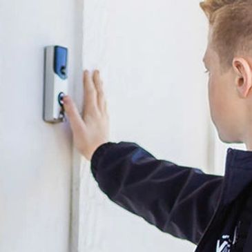 boy pressing video doorbell