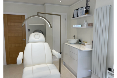 Modern white treatment chair in a clean, professional medical or spa room.