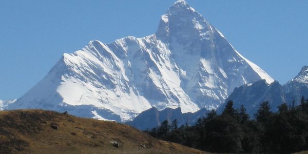 Snow-covered mountain peak against clear blue sky.