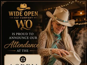 Woman in a cowboy hat holding a hat at a Wide Open Hat Company event.