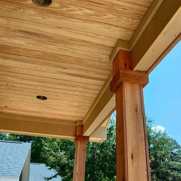 Tongue and groove porch ceiling with rough cut cedar posts and Hardie board beams