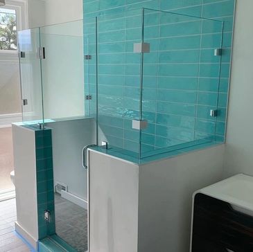 Modern bathroom shower with turquoise tiles and glass enclosure.