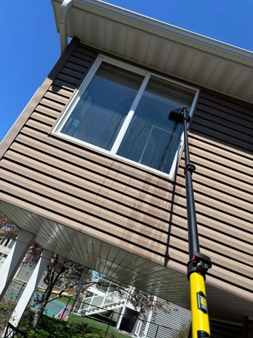 Using a Water Fed Pole to Clean a Two-Story Residential Window.