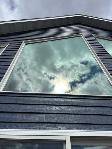 Cloudy sky reflected in a large window that we cleaned