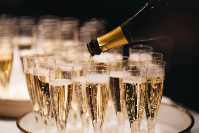 Champagne being poured into multiple flute glasses for a celebration.