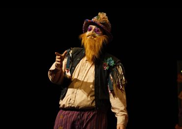 Steve in colorful wares as Autolycus in The Winter's Tale