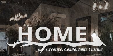 Interior of a cozy restaurant named HOME with warm lighting and rustic decor.