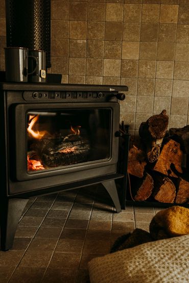 Fireplace with woodstack and cushions