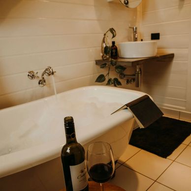 Bathroom with a Bathtub with wine and a book