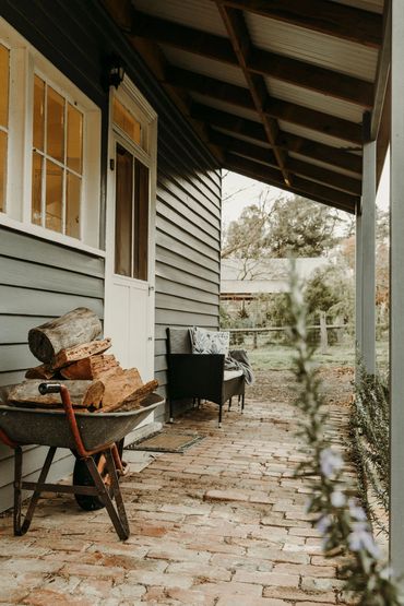 Back porch with wood pile and chait