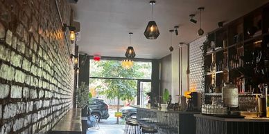 Cozy bar interior with exposed brick wall and hanging lights.