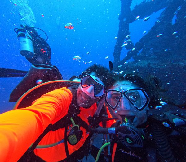 Scuba divers take a selfie at the historic USCG Duane shipwreck during a guided scuba diving tour