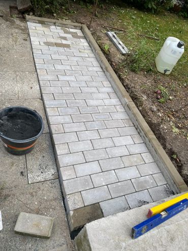 Newly laid stone pathway in a garden under construction.