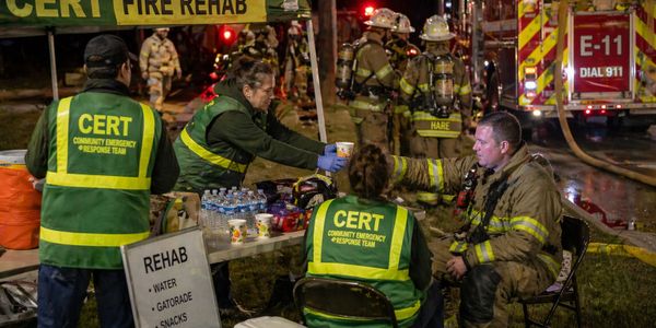 Community Emergency Response Team assisting firefighters at a fire rehab station.