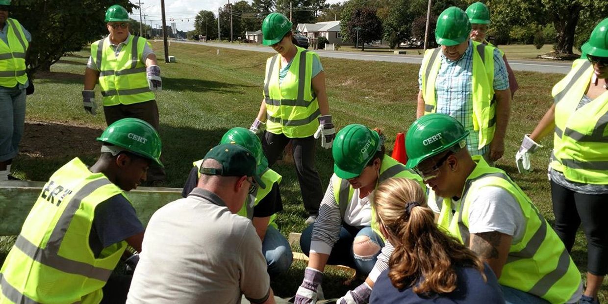 Group of people in safety gear working together outdoors.