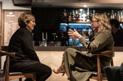 Two women chatting in a cozy bar.