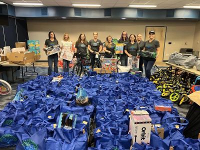 Group of volunteers with blue bags and bicycles preparing donations.